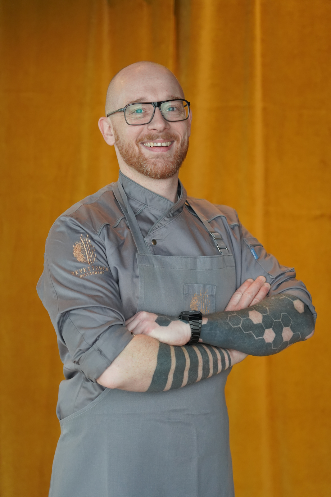 Skykitchen Küchenchef Sascha Kurgan vor einem Vorhang stehend